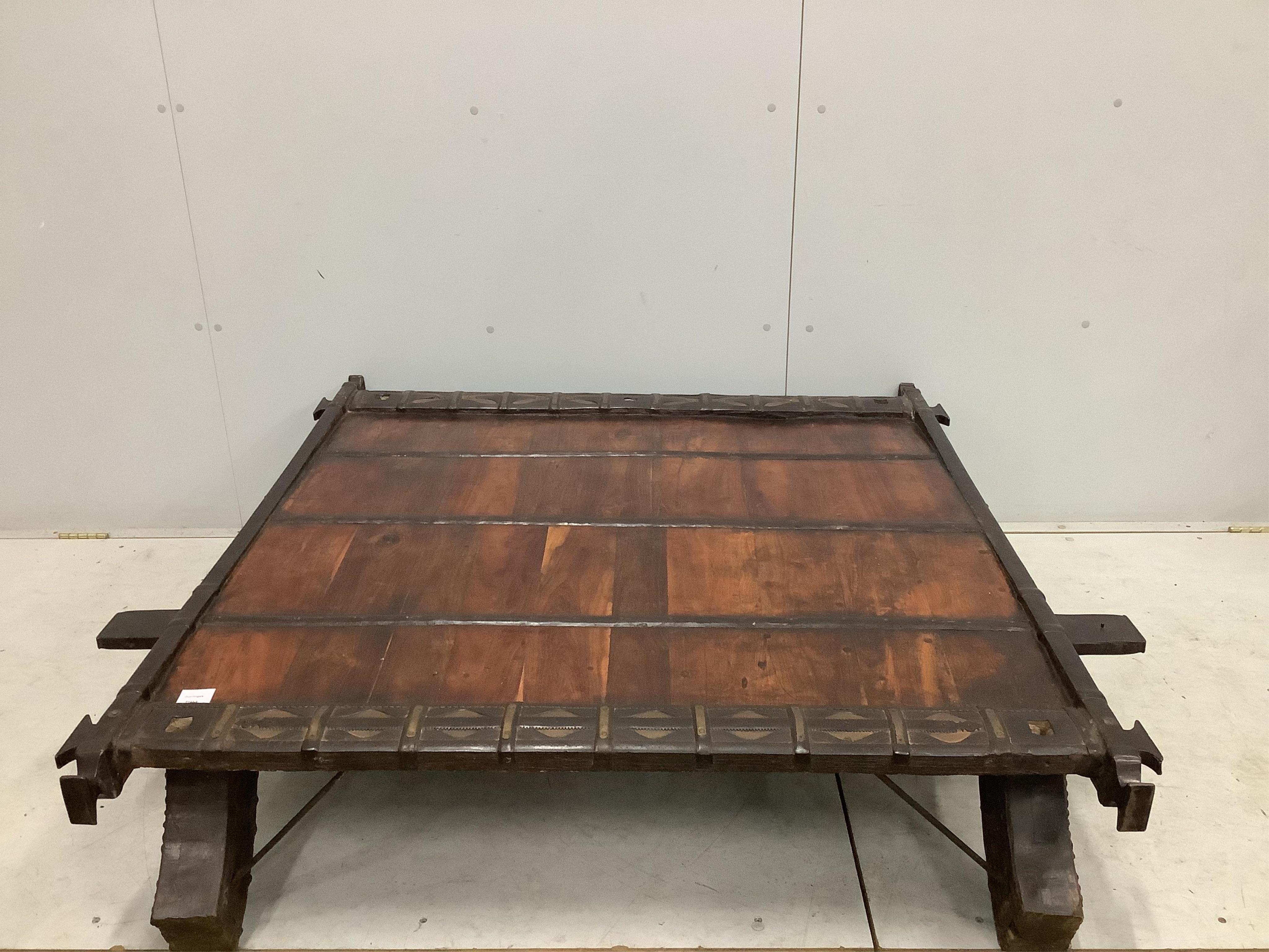 An Indian hardwood and iron mounted low square table, width 138cm, depth 130cm, height 33cm. Condition - fair